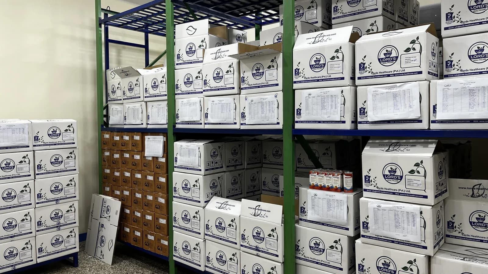 Warehouse aisle with LORD’S cartons stacked on racking and on a pallet beside it