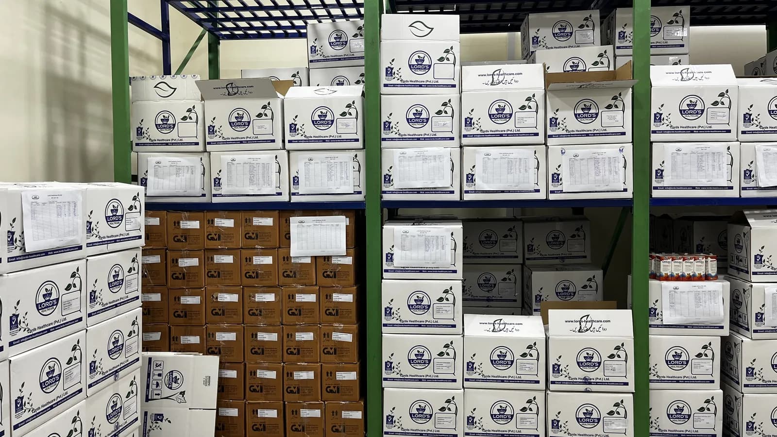 Close view of LORD’S shipper cartons on racking, each with a printed packing list attached
